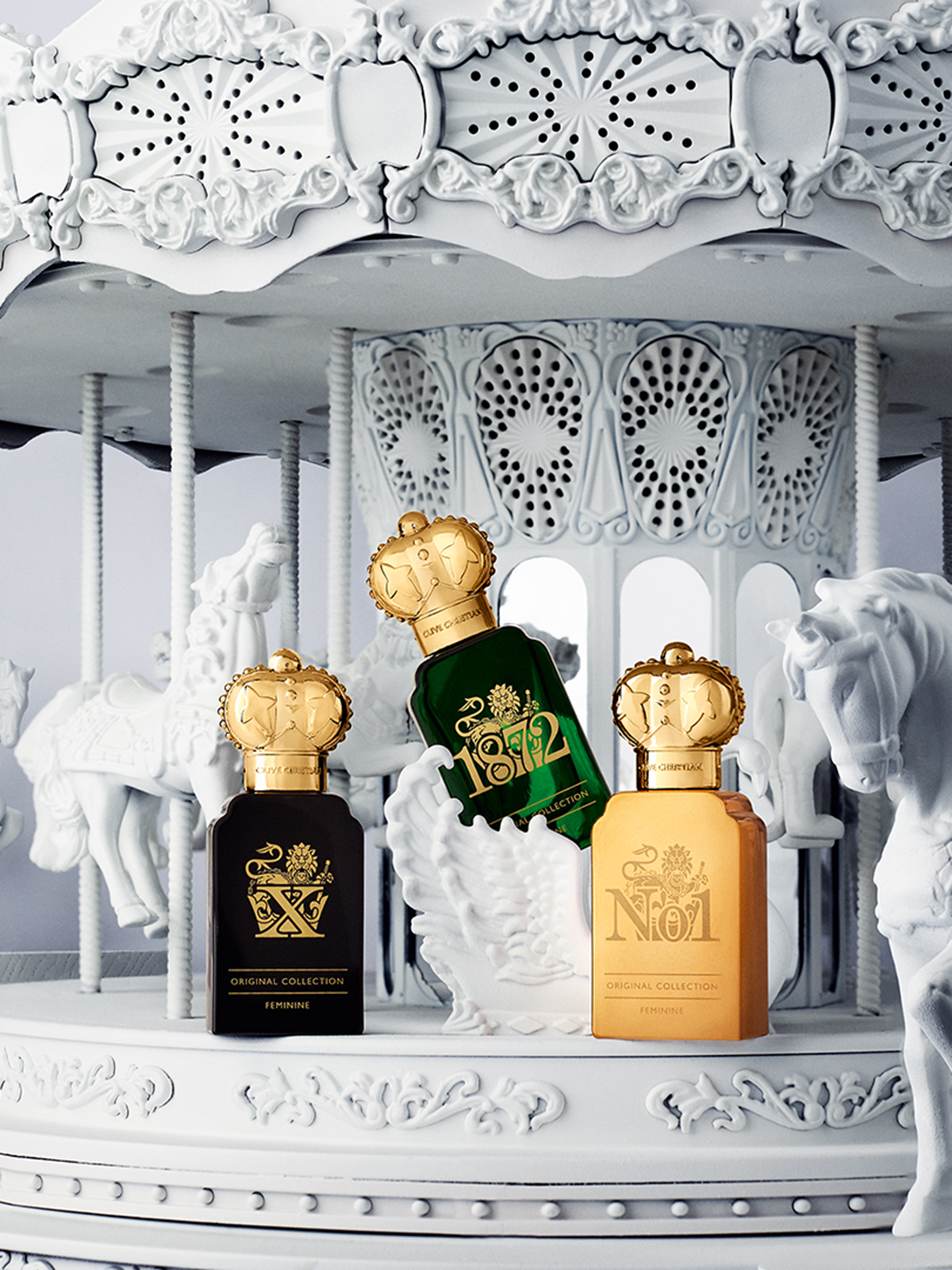 Clive Christian Original Collection featuring No.1 Feminine, 1872, and X Feminine perfumes displayed against an ornate white carousel backdrop.