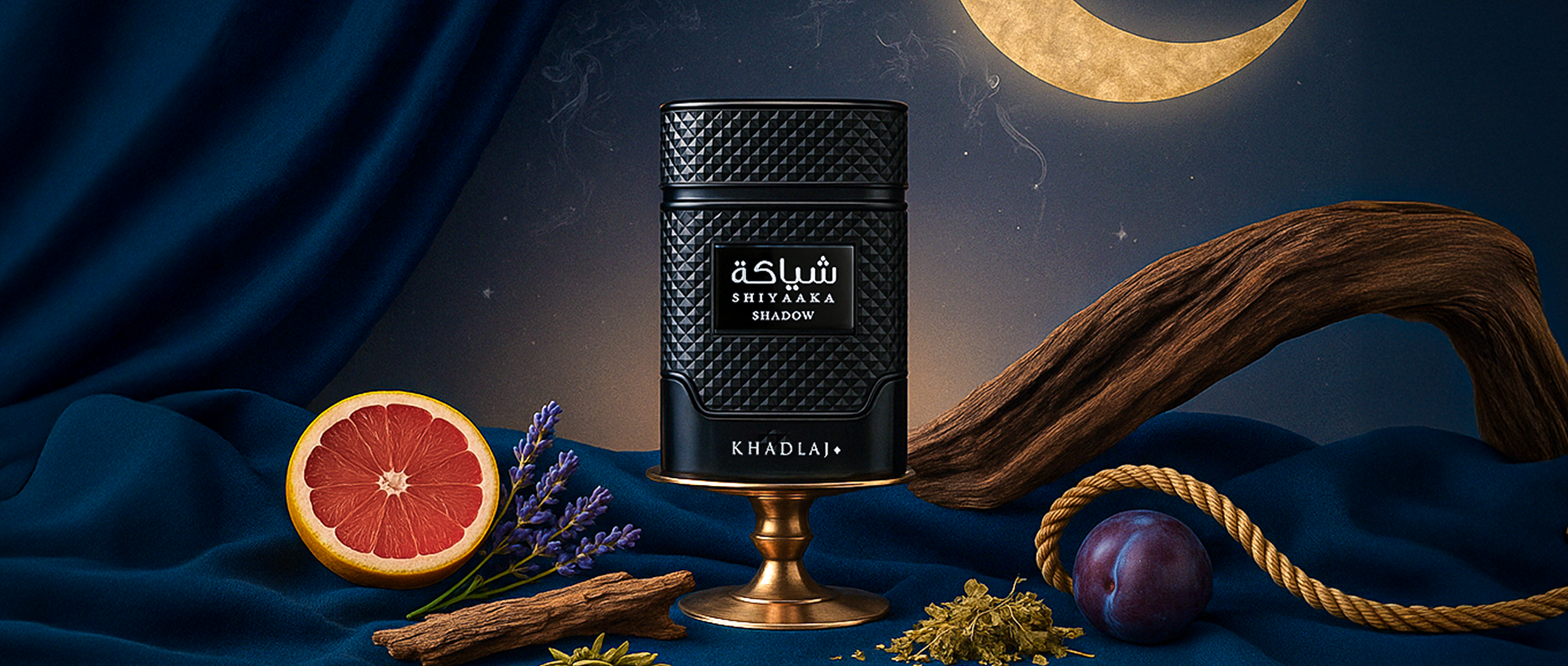 Khadlaj Shiyaaka Shadow perfume bottle on dark blue fabric with moon backdrop.