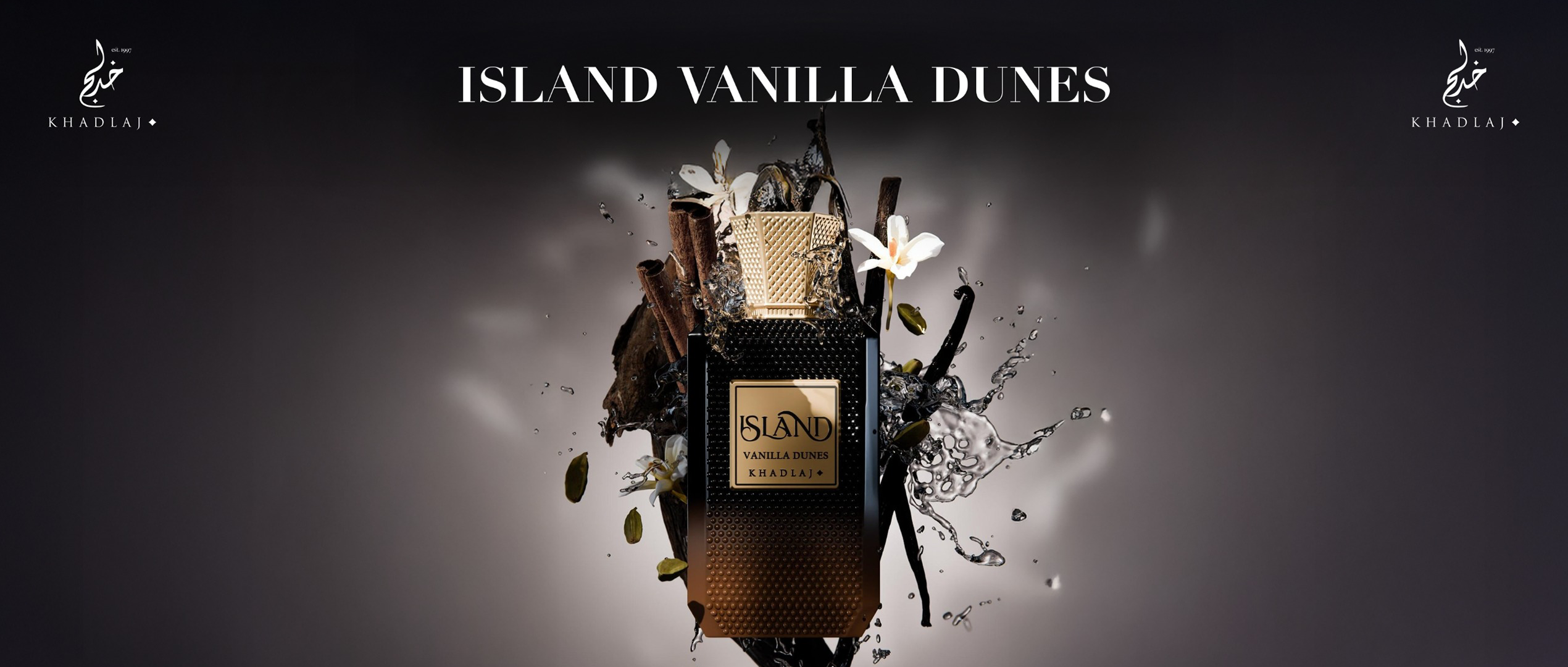 A luxurious black and gold Khadlaj perfume bottle labeled “Island Vanilla Dunes” stands amid splashing water, vanilla pods, cinnamon, and white flowers, evoking a rich tropical allure.