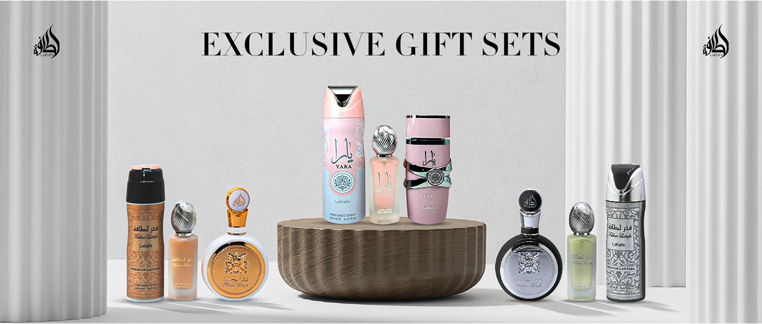 Lattafa Exclusive Gift Sets featuring Yara and Fakhar Lattafa collections, displayed with perfumes and matching body sprays on a white background with elegant pillars.