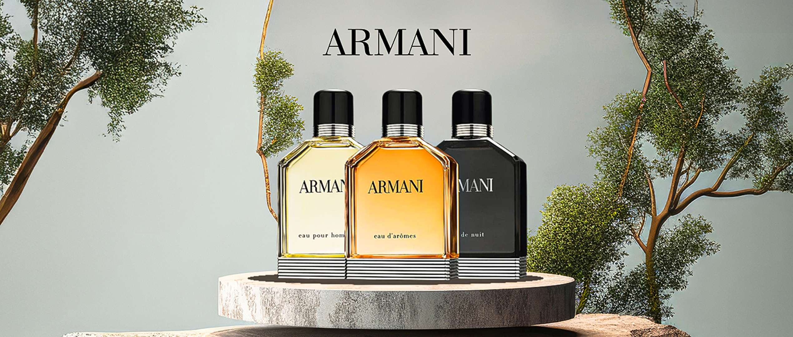 Armani fragrance collection featuring Eau Pour Homme, Eau d’Arômes, and Eau de Nuit bottles displayed on a stone pedestal with natural tree background.”