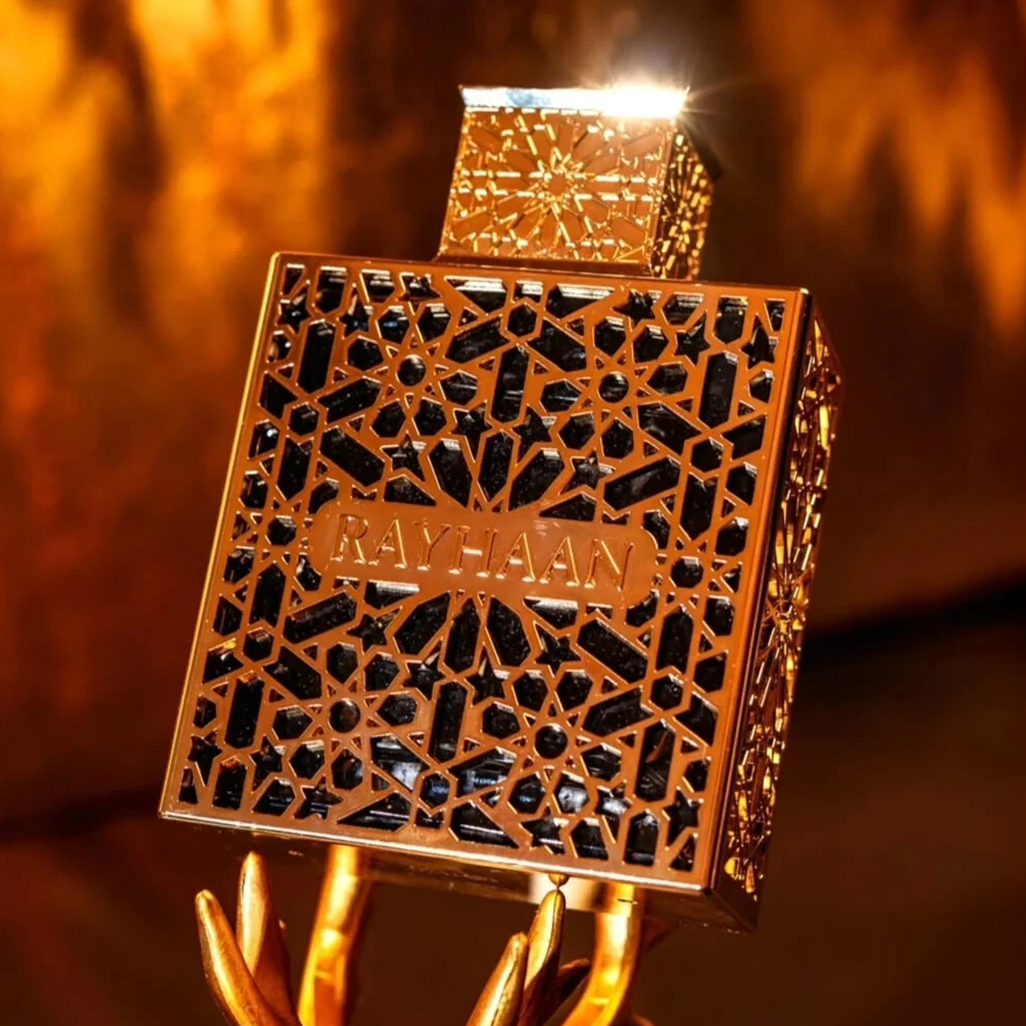 A luxurious Rayhaan Elixir perfume bottle with intricate golden lattice design and black detailing, glowing warmly against a golden background.