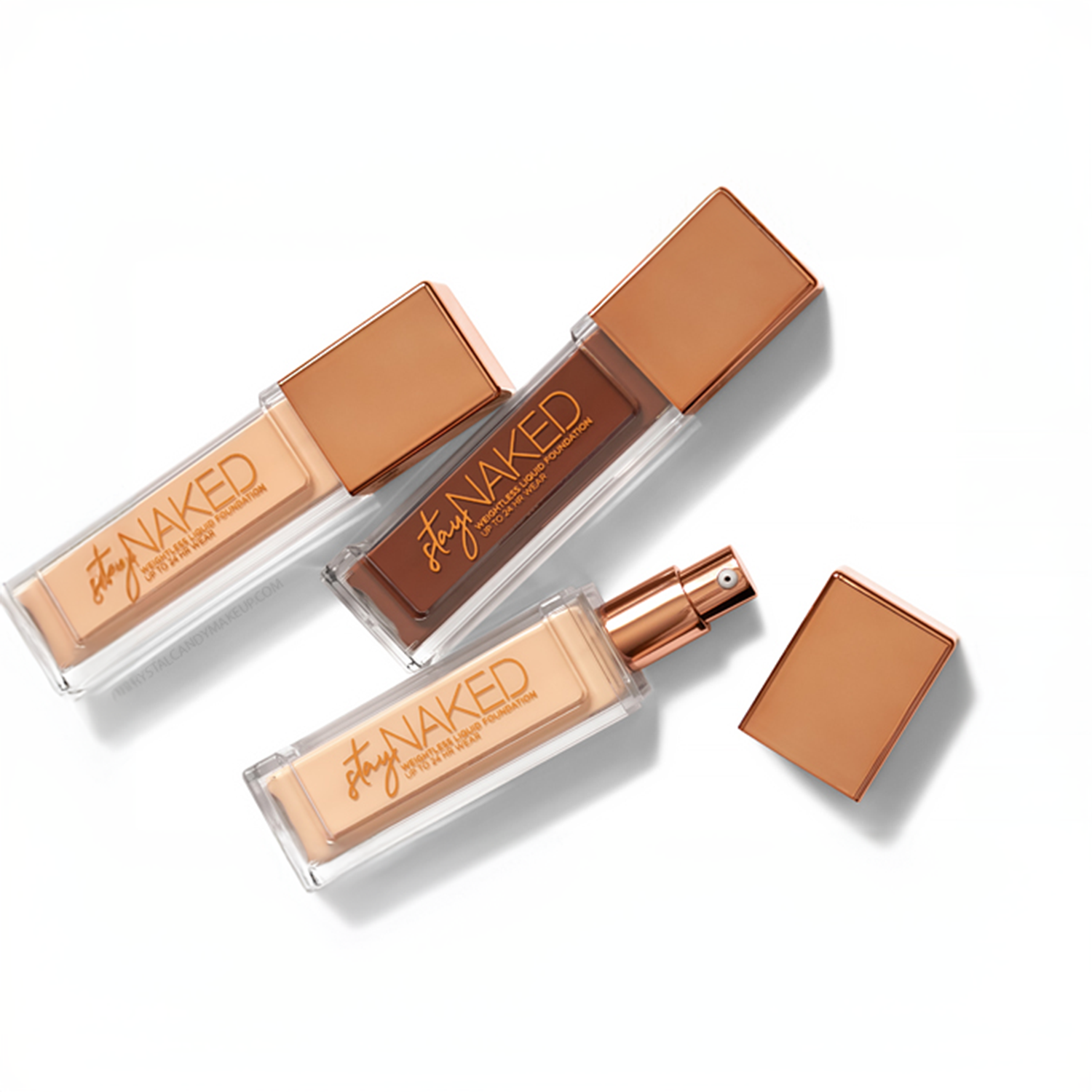 Urban Decay Stay Naked Weightless Liquid Foundation bottles in different shades, with sleek rose-gold caps, displayed on a white background.