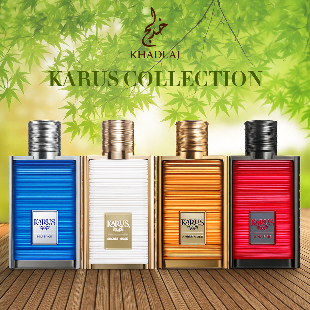 Four colorful perfume bottles from Khadlaj’s Karus Collection—blue, white, gold, and red—stand on a wooden surface under green leaves, evoking freshness and elegance.
