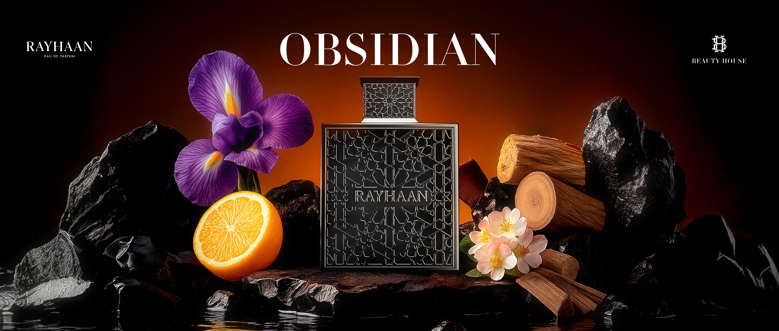 A luxurious black Rayhaan Obsidian perfume bottle is showcased against a warm, fiery background. Surrounded by dark stones, wood, orange slices, and delicate flowers, the composition evokes depth, mystery, and elegance.